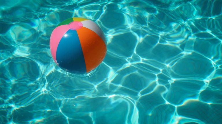summer-beach-ball-pool-protect-hearing A beach ball floating in a pool.
