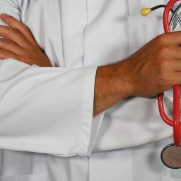 A doctor holding a red stethoscope.