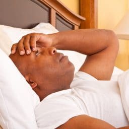 Man lying awake in bed.