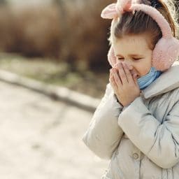 Child covering her nose with her hands.