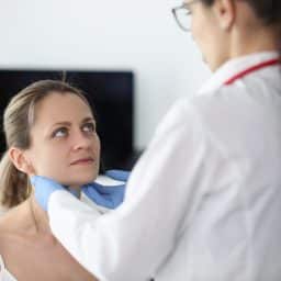 Doctor examining a woman's salivary glands.