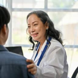 A doctor reassuring a patient during an appointment.