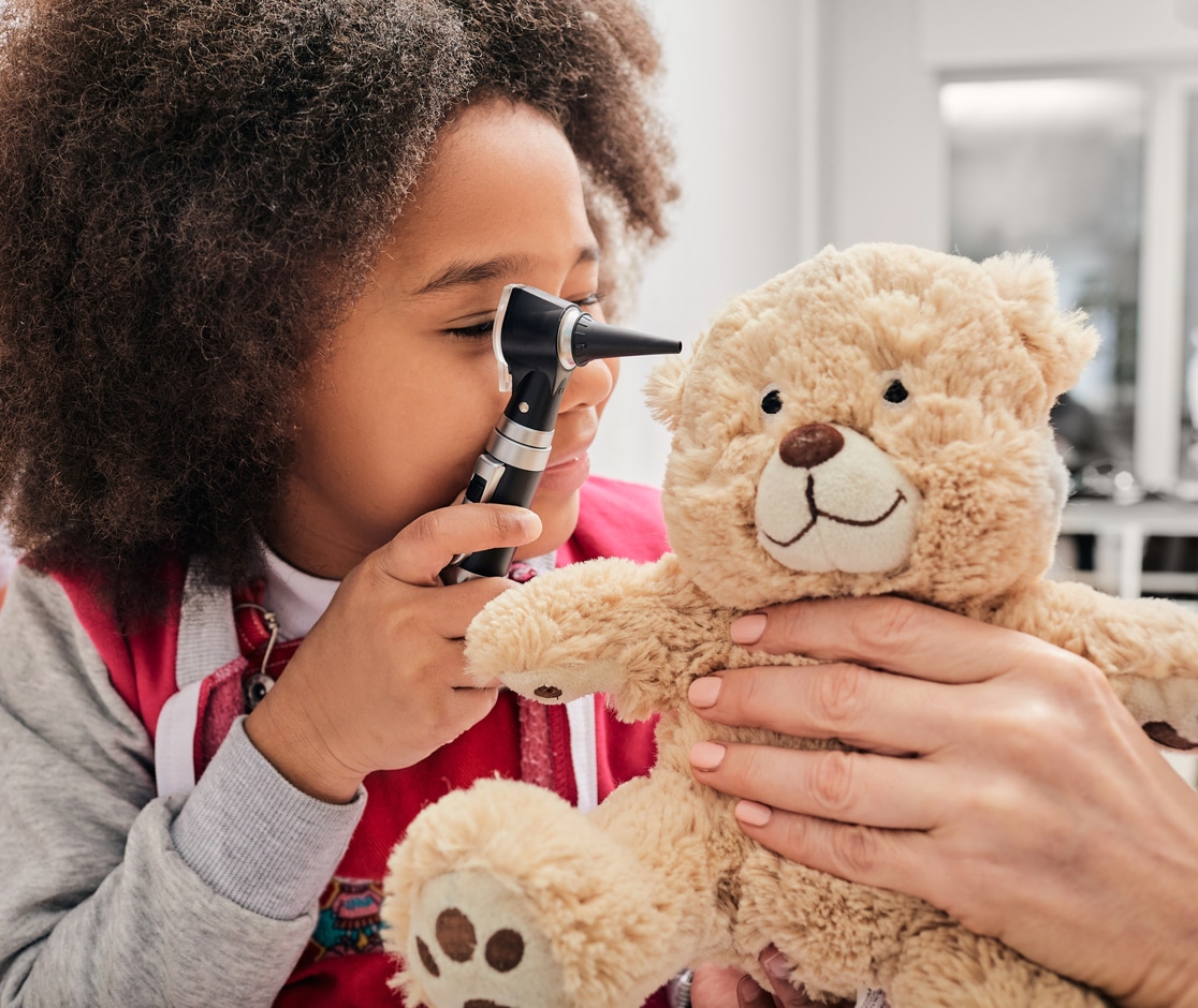Child at doctor's office plays with teddy bear