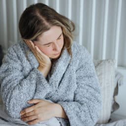 Woman holds her ear in pain