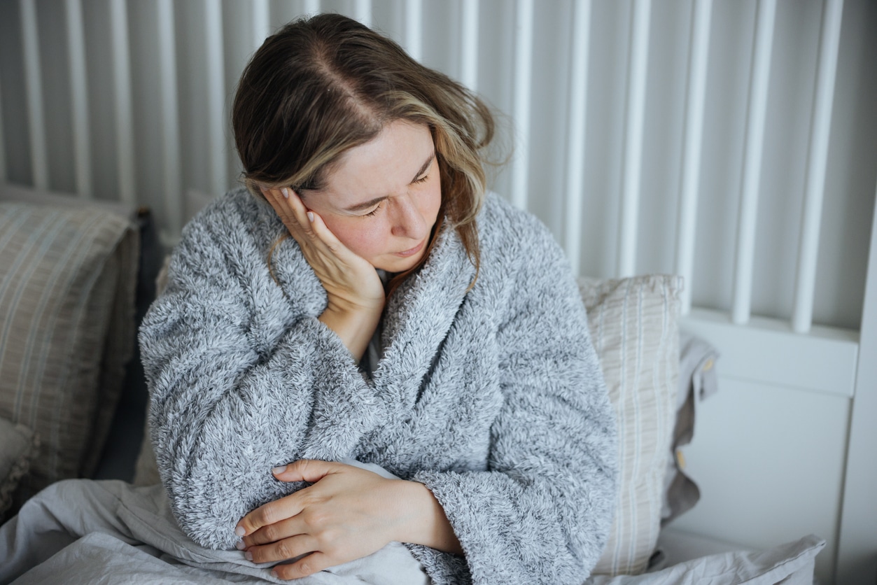 Woman holds her ear in pain
