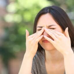 Woman scratching itchy eyes in the street