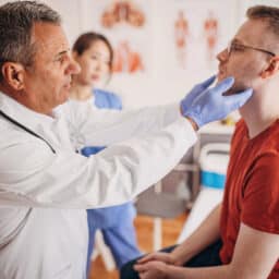 ENT doctor performing a thyroid exam