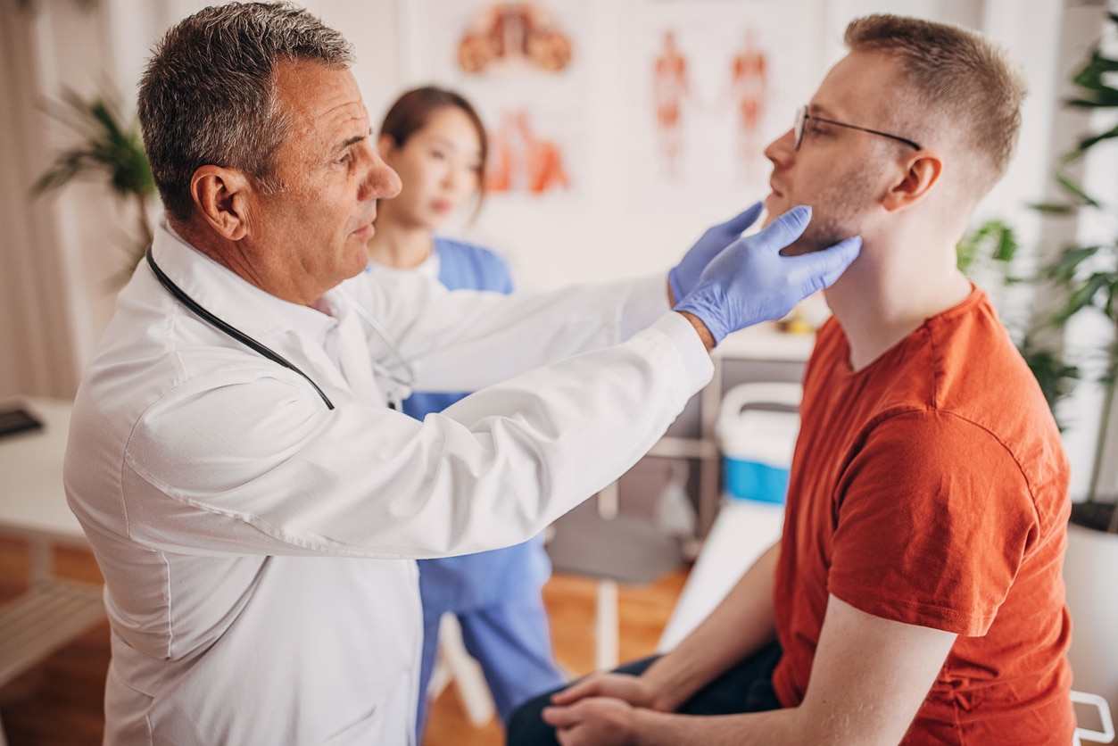 ENT doctor performing a thyroid exam