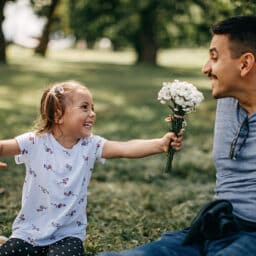 Man with allergies is sniffle-free thanks to sublingual immunotherapy as his daughter hands him a spring bouquet of flowers