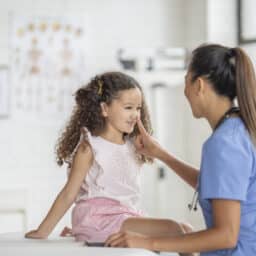 Allergist teases her pediatric patient by touching her nose after administering a dose of allergen immunotherapy to treat the child's allergies.